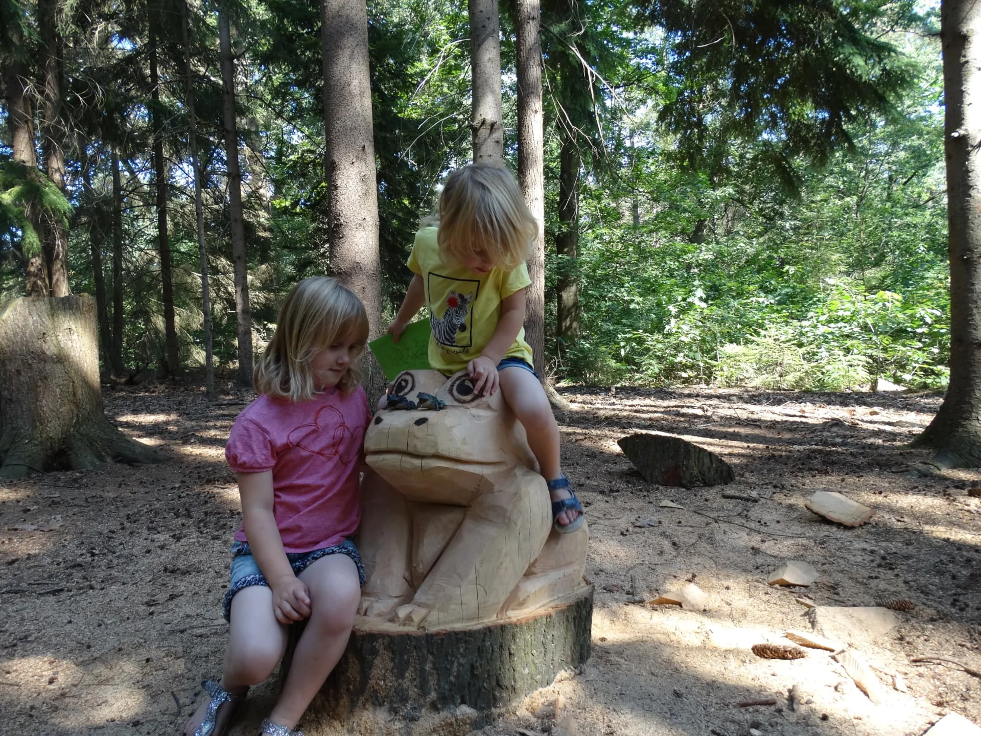 Twee meisjes bij de grote houten kikker op het Groote Kikkerpad