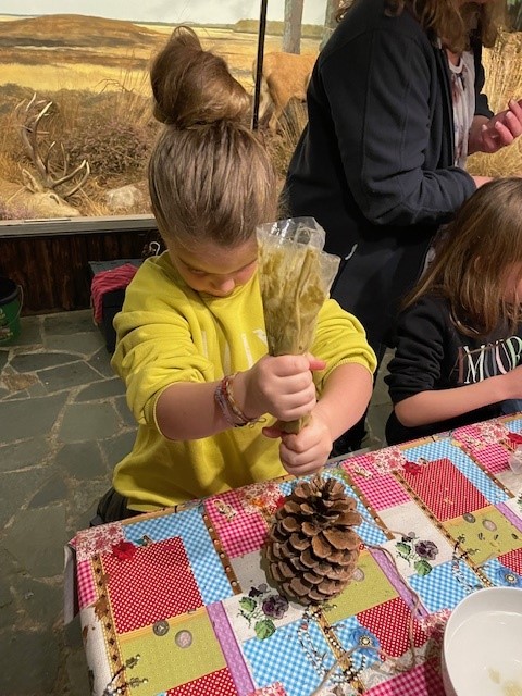 Een kind maakt vogelvoer tijdens een activiteit in het museum